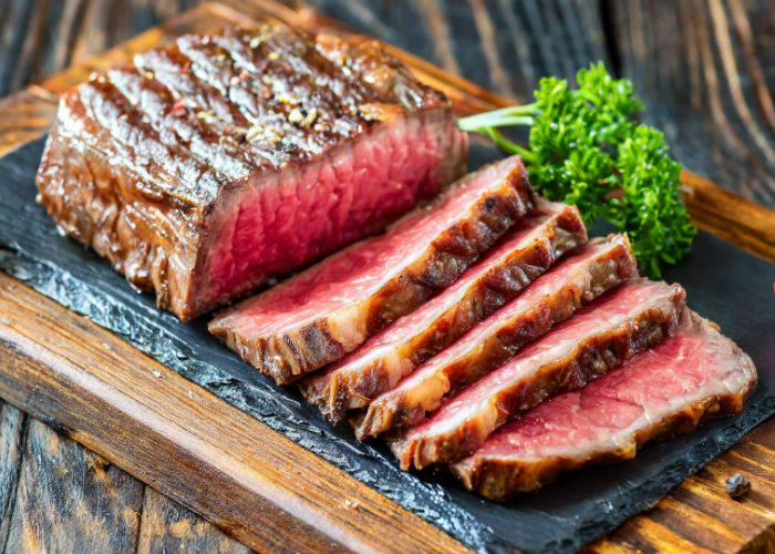 A thick slab of wagyu beef slices, sliced to reveal a medium-rare interior.